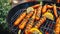 Grilled carrots in a herbal marinade on a grill plate, outdoor, top view. Grilled vegetarian food