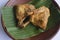 Grilled chicken  or ayam panggang served with banana leaf, onion on earthenware plates, isolated on white background