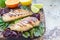 Grilled chicken breast in citrus marinade on salad leaves and wooden board, horizontal, copy space