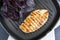 Grilled chicken breast steak with violet basil on teflon pan grill