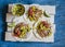 Grilled chicken and corn salsa tortilla on a wooden board on blue background. Top view