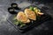 Grilled chicken fillets on slate plate. Gray concrete background