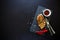 Grilled chicken fillets on slate plate with rosemary, pepper, ketchup and spices on dark wooden background. Top view. Flat lay.