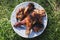 Grilled chicken is lying on the plate outdoors on green grass background. Summer tasty food photo