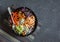 Grilled chicken, rice, spicy chickpeas, avocado mash, cabbage, pepper buddha bowl on dark background, top view. Delicious balanced