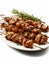 Grilled chicken skewers on a plate with rosemary sprigs