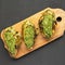 Grilled chimichurri chicken breast on a rustic wooden board on a black surface, top view. Flat lay, overhead, from above. Close-up