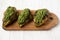 Grilled chimichurri chicken breast on a rustic wooden board on a white wooden background, low angle view. Close-up