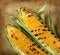 Grilled corn cobs on rustic stone background