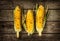 Grilled corn cobs on vintage wood background