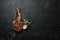 Grilled cowboy beef steak, herbs and spices on a black stone background. Barbecue. Top view.