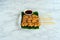 Grilled crocodile steak with Thai spicy dipping sauce or Jaew sauce on banana leaf above white plate on marble background. BBQ