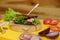 Grilled dark bread sandwich on wooden plate on yellow board