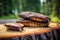 grilled eggplant on cedar plank, displayed on outdoor picnic table