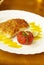 Grilled fish with orange sauce and baked tomato