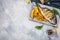 Grilled fish on stone plate with lemon on concrete background, top view