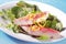 Grilled fresh fish fillets on leafy green salad