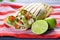 grilled goat cheese taco on a striped cloth with cut limes