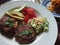 Grilled grassfed organic hamburgers with coldslaw and avocado chef plate