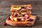 Grilled holiday turkey, cranberry and brie sandwich stack on a serving board against wood