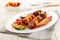 Grilled hungarian meat vegetables skewers on an oval plate