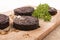 Grilled irish black pudding with parsley on a wooden board