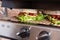 Grilled long sandwich or panini on the grill of an electric grill. Crisp bread, lettuce, tomato, cheddar, salsa sauce -