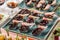 Grilled meat fillet canapes with baked pear and berry sauce in spoon on banquet table. Catering food, appetizer platter and snacks
