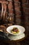 Grilled meat fillet steak medallion with green sauce, served with pear or apple. On dark background