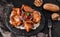 Grilled meat or shish kebab, shashlik on pita bread with tomato sauce on slate board over dark stone background. Top view