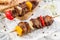 Grilled meat shish on skewers with vegetables on paper over light table. Healthy food. Hot meat dishes, shashlik food, closeup