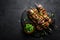 Grilled meat skewers, shish kebab on black background, top view