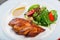 Grilled meat steak and salad with grilled vegetables, arugula and spinach in plate on dark wooden background.