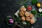 Grilled medallions wrapped in bacon. in a pan, ready to eat. On a black concrete background.