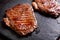 Grilled minute steak of marbled beef on a stone slate board, close up