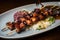 Grilled octopus skewers with a savory miso glaze, served with steaming jasmine rice and a side of pickled ginger and wasabi