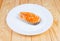 Grilled piece of arctic char on white dish close-up