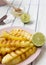 Grilled pineapple slices on a pink plate with honey and lime, low angle. Summer food. Close-up. Selective focus