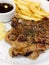 Grilled pork steak with sliced pineapple and frech fries on white dish background