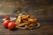 Grilled potatoes with cherry tomatoes and sauce on a cork stand on a dark wooden background