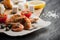 Grilled prawns on the peace of paper with tomatoes, cheese and bread on the wooden board