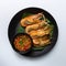 Grilled prawns with spicy dipping sauce on banana leaf in black disk on white background