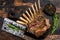 Grilled rack ribs of lamb meat chops. Dark wooden background. Top view