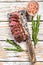 Grilled ramp cap steak on a meat cleaver. White wooden background. Top view