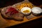 Grilled rare beef steak served on wooden board with fried potatoes