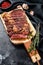 Grilled rib eye, ribeye steak on a chopping Board, medium rare. marbled meat. black background. top view