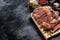 Grilled rib eye, ribeye steak on a chopping Board, medium rare. marbled meat. black background. top view. Copy space