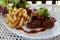 Grilled rib steak serving with french fried and lettuce salad