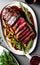 Grilled ribeye beef steak with red wine, herbs and spices, food advertisement photo,