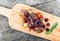 Grilled Ribeye Steak on bone with berry sauce, potatoes, tomatoes and rosemary on cutting board on wooden background